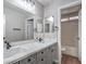 Bright bathroom featuring a dual sink vanity with a modern faucet and gray cabinets at 7619 Comanche Canyon Ave, Las Vegas, NV 89113