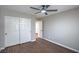 Neutrally painted bedroom with fan and white closet, offering modern simplicity at 7619 Comanche Canyon Ave, Las Vegas, NV 89113