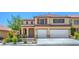 Two-story stucco house with a tile roof, brown shutters, and a two-car garage and landscaped front yard at 7619 Comanche Canyon Ave, Las Vegas, NV 89113