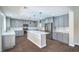 Open-concept kitchen features gray cabinets, stainless steel appliances, and a large center island at 7619 Comanche Canyon Ave, Las Vegas, NV 89113