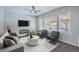 Bright living room featuring a modern sofa, grey chairs, TV, decorative fireplace and large windows at 7619 Comanche Canyon Ave, Las Vegas, NV 89113