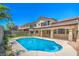 A backyard pool with patio, fencing, and grass in a well-maintained outdoor living space under a clear blue sky at 7619 Comanche Canyon Ave, Las Vegas, NV 89113
