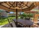 Cozy backyard patio under a tiki umbrella, with outdoor seating and a tranquil garden view at 7818 Brodie Castle Ct, Las Vegas, NV 89166