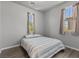 Cozy bedroom with hardwood flooring, two windows, and a comfortable striped bedspread at 7818 Brodie Castle Ct, Las Vegas, NV 89166
