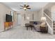Inviting living room with tile flooring, neutral walls, ceiling fan, and staircase at 7818 Brodie Castle Ct, Las Vegas, NV 89166