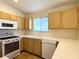 Efficient kitchen with wood cabinets and white appliances at 7830 Foxwood Pl # 7830, Las Vegas, NV 89145