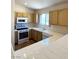 Functional kitchen with white appliances, natural wood cabinets, and plenty of counter space at 7830 Foxwood Pl # 7830, Las Vegas, NV 89145