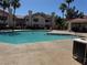Community pool with palm trees and lounge chairs for residents to enjoy on a sunny day at 7830 Foxwood Pl # 7830, Las Vegas, NV 89145
