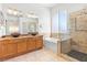 Bathroom featuring double vanity sinks, soaking tub, and glass enclosed shower at 786 Craigmark Ct, Henderson, NV 89002
