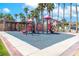 Community playground with colorful equipment, surrounded by lush green spaces and tall palm trees at 786 Craigmark Ct, Henderson, NV 89002