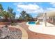 Inviting backyard pool with desert landscaping, brick accents, and a covered patio for relaxing at 786 Craigmark Ct, Henderson, NV 89002
