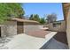 Backyard view of a stucco home with a detached garage and low-maintenance landscaping at 809 Greenbrook St, Las Vegas, NV 89110