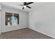 Carpeted bedroom features a ceiling fan, window with security bars, and natural light at 809 Greenbrook St, Las Vegas, NV 89110