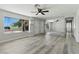 Bright living room with wood-look floors, ceiling fan, large windows, and mirrored wall at 809 Greenbrook St, Las Vegas, NV 89110