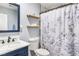 Bathroom with marble countertop, dark blue vanity and a shower with floral curtain at 824 Antigua St, Las Vegas, NV 89145