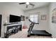 Well-lit bedroom featuring treadmill, tv, and a ceiling fan to create a comfortable and functional space at 83 Buckthorn Ridge Ct, Las Vegas, NV 89183