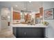 Modern kitchen with stainless steel appliances, a black waterfall island and stylish pendant lighting at 83 Buckthorn Ridge Ct, Las Vegas, NV 89183