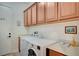 Functional laundry room features modern washer and dryer, overhead cabinets, and a folding counter for convenience at 83 Buckthorn Ridge Ct, Las Vegas, NV 89183
