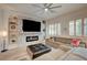 Well-lit living room featuring a decorative fireplace, stylish furniture, plantation shutters, and wood-look flooring at 83 Buckthorn Ridge Ct, Las Vegas, NV 89183