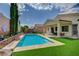 Inviting backyard pool with lush green turf, complemented by verdant landscaping for a serene outdoor oasis at 83 Buckthorn Ridge Ct, Las Vegas, NV 89183