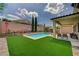 Enjoy this backyard oasis with a sparkling pool, covered patio, and green artificial turf at 83 Buckthorn Ridge Ct, Las Vegas, NV 89183