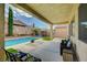 Relax under a covered patio by the pool in this backyard retreat at 83 Buckthorn Ridge Ct, Las Vegas, NV 89183