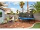 Landscaped backyard featuring a trampoline, fire pit, and mature landscaping providing privacy at 8484 Montana Stream Ave, Las Vegas, NV 89113