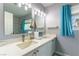 Bathroom featuring a double vanity, framed mirror, decorative lighting and view to the backyard at 8484 Montana Stream Ave, Las Vegas, NV 89113