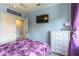 Bedroom features a mounted television, plush carpet, and a view of the hallway at 8484 Montana Stream Ave, Las Vegas, NV 89113