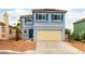 Charming two-story home with a blue exterior, blue shutters, desert-landscaped front yard, and a two-car garage at 8484 Montana Stream Ave, Las Vegas, NV 89113