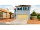 Two-story home with a blue exterior, red roof, tan garage door, and a desert-landscaped front yard at 8484 Montana Stream Ave, Las Vegas, NV 89113