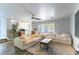 Open-concept living room with wood-look floors, a large sofa, ceiling fan, and access to the backyard at 8484 Montana Stream Ave, Las Vegas, NV 89113