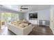 Comfortable living room with a large sofa, wood-look floors, ceiling fan, and sliding glass doors at 8484 Montana Stream Ave, Las Vegas, NV 89113