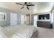 Spacious main bedroom with a ceiling fan, TV, carpet floors and access to the ensuite bathroom at 8484 Montana Stream Ave, Las Vegas, NV 89113