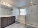 Modern bathroom features a double vanity, soaking tub, and glass-enclosed shower, offering a spa-like experience at 889 Harbor Ave, Henderson, NV 89002