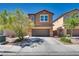 Two-story home featuring a well-manicured lawn, covered porch and a two-car garage at 889 Harbor Ave, Henderson, NV 89002