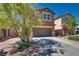 Traditional home showcasing a well-maintained lawn, mature trees, and an attached two-car garage at 889 Harbor Ave, Henderson, NV 89002