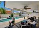 Covered back patio with a pool view, ceiling fans, lounge furniture, and exercise equipment at 8953 Paige Rene Ct, Las Vegas, NV 89117