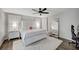 Bright bedroom with a white bed set, ceiling fan, and a full-length mirror for a spacious feel at 8953 Paige Rene Ct, Las Vegas, NV 89117