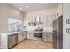 Well-lit kitchen features stainless steel appliances, bright white marble countertops, and light cabinetry at 9220 Pitching Wedge Dr, Las Vegas, NV 89134