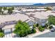 Aerial view showcasing homes with light tile roofs in a well-planned community surrounded by desert landscape at 9357 Golden Timber Ln, Las Vegas, NV 89117