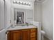 Bathroom with a wood vanity, large mirror, and a toilet in its own separate area at 9357 Golden Timber Ln, Las Vegas, NV 89117