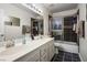 Bathroom featuring double sinks, a large mirror, and a tiled shower/bathtub at 9357 Golden Timber Ln, Las Vegas, NV 89117