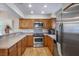 Well-lit kitchen featuring stainless steel appliances, warm wood cabinets and flooring, and ample counter space at 9357 Golden Timber Ln, Las Vegas, NV 89117