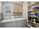 Convenient laundry area with a side-by-side washer and dryer and built in shelves for storage at 9357 Golden Timber Ln, Las Vegas, NV 89117