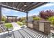 Covered patio in a backyard with an outdoor kitchen, seating, and views of the landscape at , Las Vegas, NV 89149