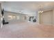 Spacious living room with neutral carpeting and views of the open-concept kitchen and fireplace at , Las Vegas, NV 89149