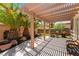Inviting backyard patio shaded by a pergola with seating area, palm trees, and desert landscaping at 10331 Rio De Thule Ln, Las Vegas, NV 89135