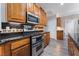 Kitchen with gray wood floors, dark countertops, stainless steel appliances, and dark backsplash at 10331 Rio De Thule Ln, Las Vegas, NV 89135