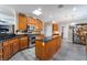 Kitchen featuring gray wood floors, dark countertops, wooden cabinets, an island, and stainless steel appliances at 10331 Rio De Thule Ln, Las Vegas, NV 89135